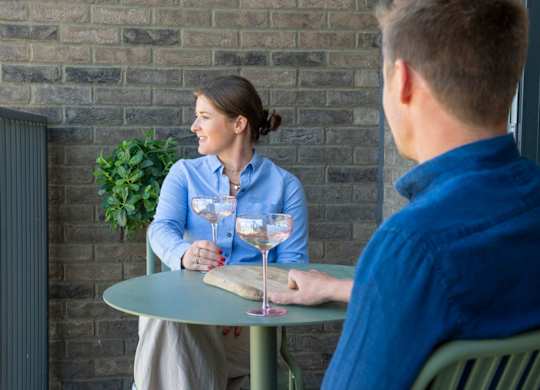 Man and a woman are sitting at a table with drinks at The Lark, London, SW11 7EA