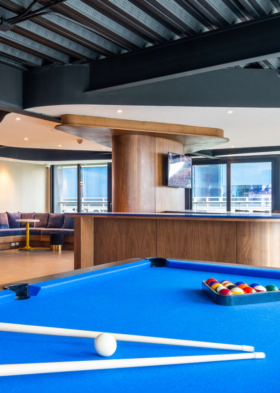 a pool table and bar in a lounge area