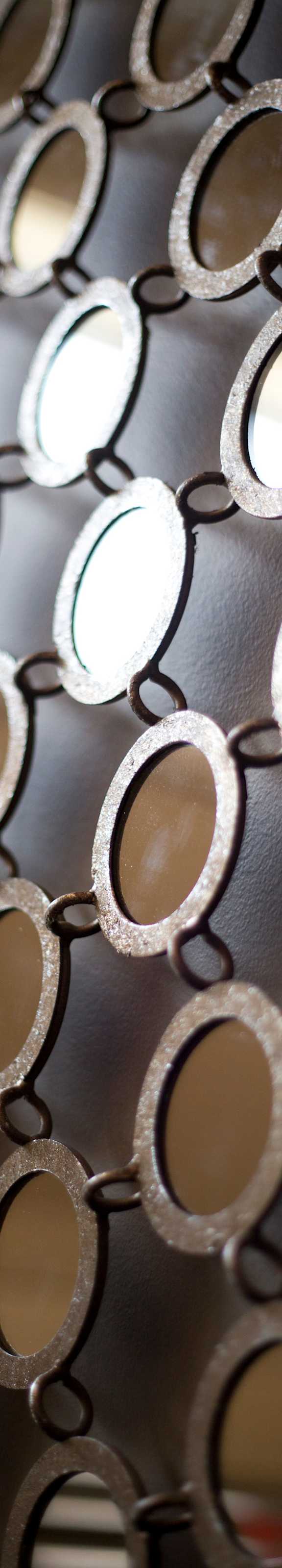 A close up of a chain link fence with circular gaps.