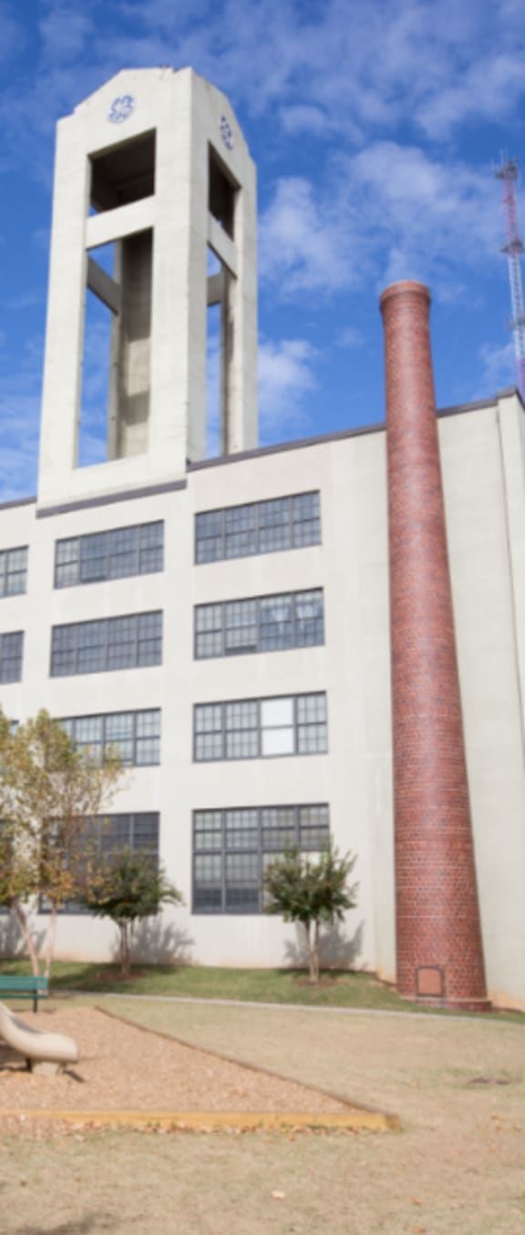 a large white building with a tall brick chimney