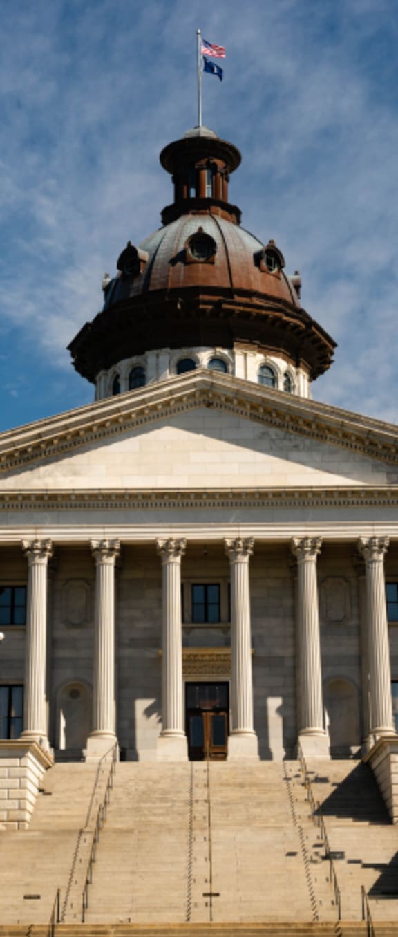 the front of a building with a dome and a flag at Carrington Place at Wildewood, Columbia South Carolina