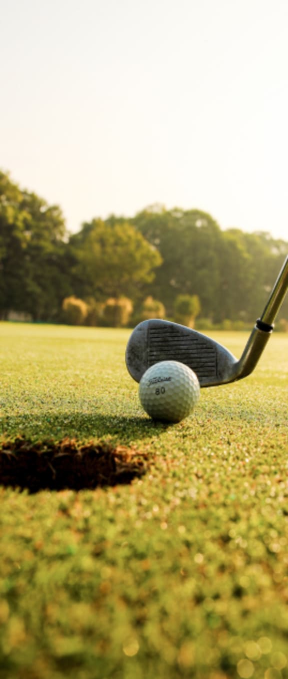 a golfer teeing off on a golf course at Pendleton Townhomes Apartments, Durham, NC