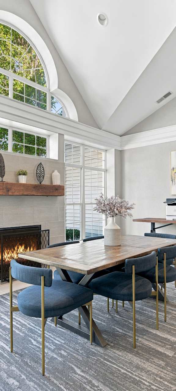 A dining room with a fireplace and a table set for four.