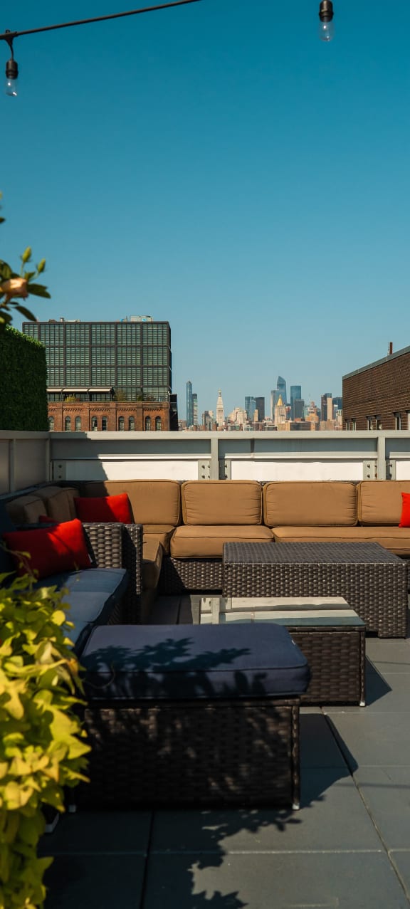 a roof top patio with furniture and a view of the city at 34 Berry, Brooklyn, 11249