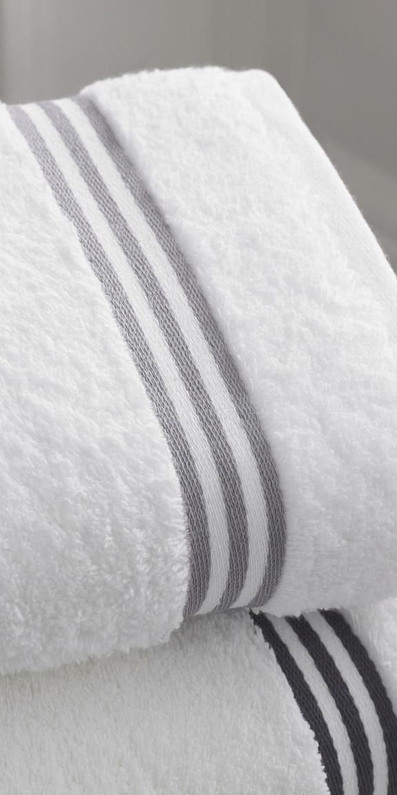 a white towel with black and white stripes on top of a bed