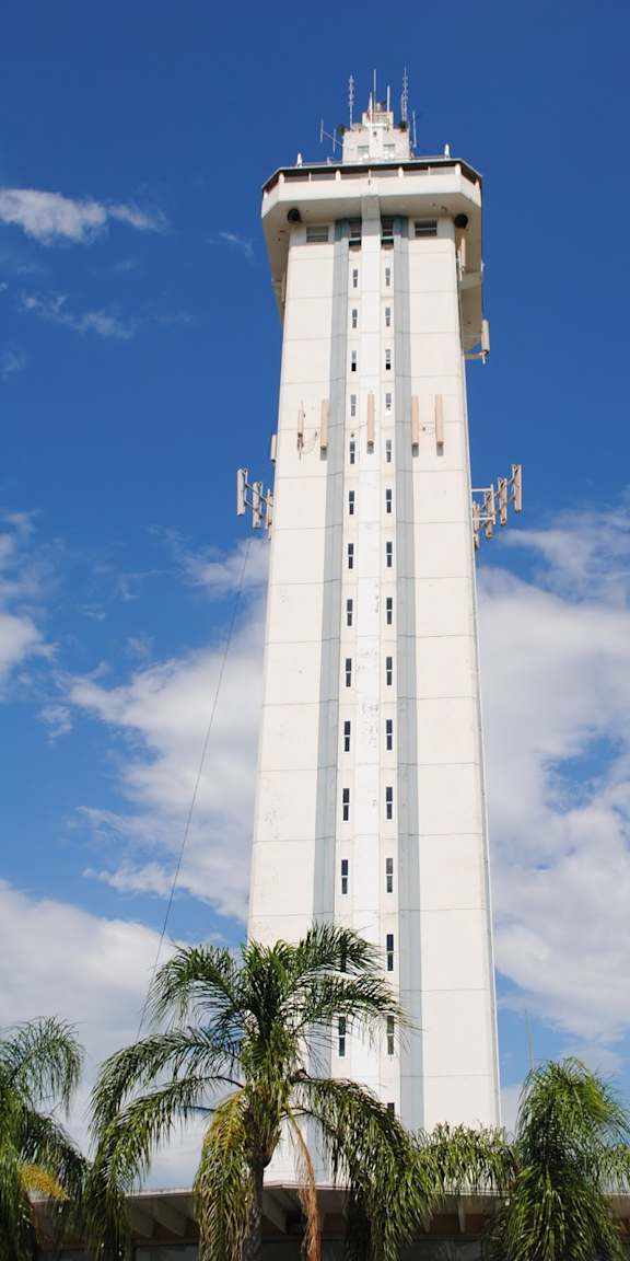 A tall white tower with a blue sky in the background.