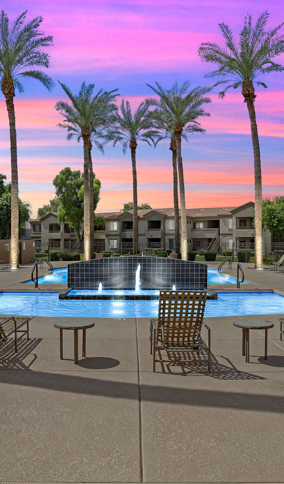 A pool surrounded by palm trees and chairs.