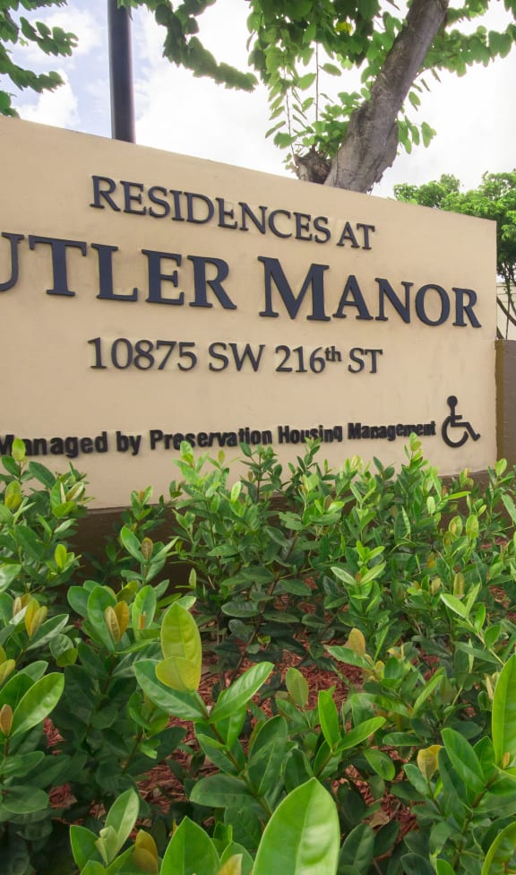 a picture of theucci manor sign in front of the building
