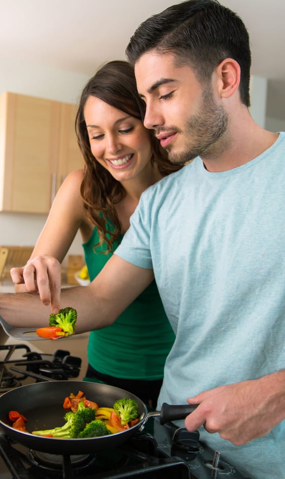 a man and a woman cooking in a kitchen