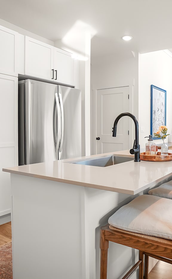 A kitchen with white cabinets and a black stove top.