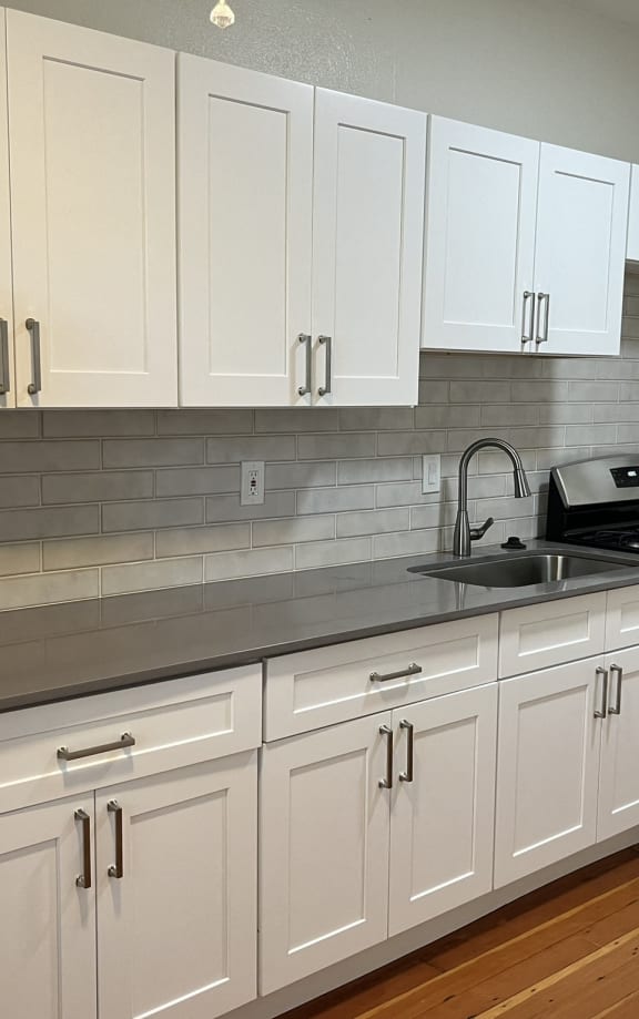 a kitchen with white cabinets and a sink and a refrigerator