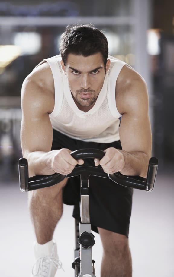 a man riding an exercise bike in a gym at Altis Twin Lakes Apartments, Kissimmee, FL 34744