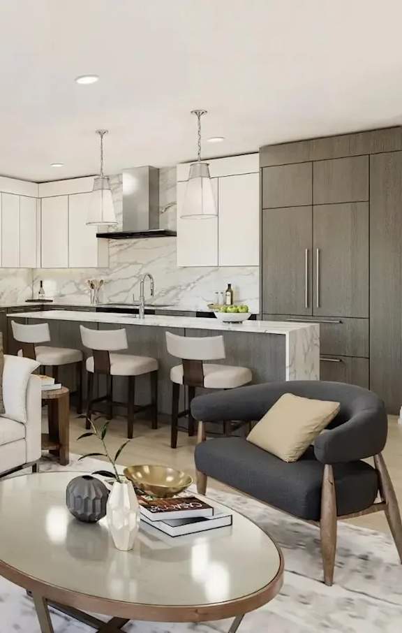 A modern kitchen with a marble countertop and a grey armchair.