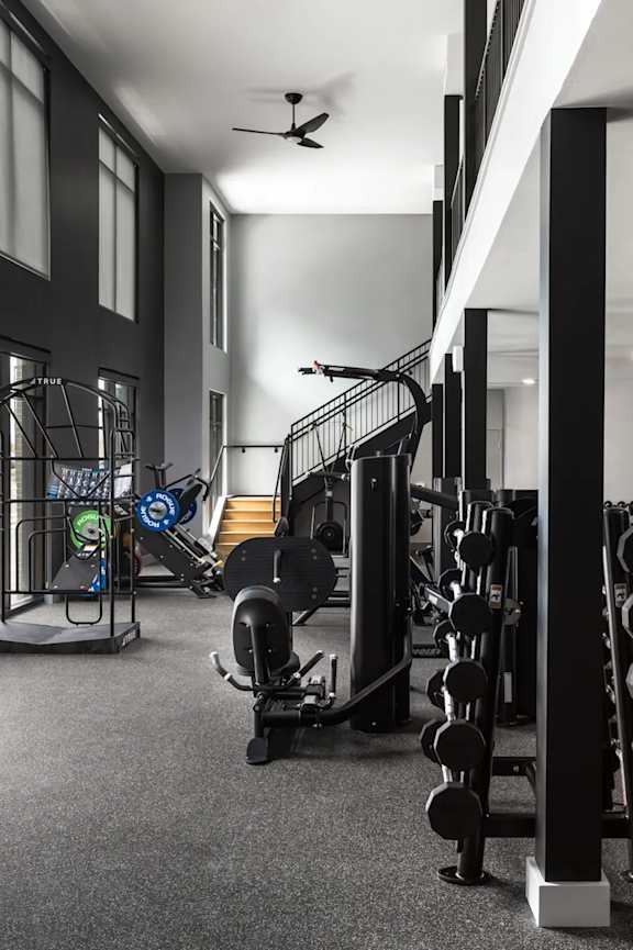 A black and white photo of a gym with weights and exercise equipment.