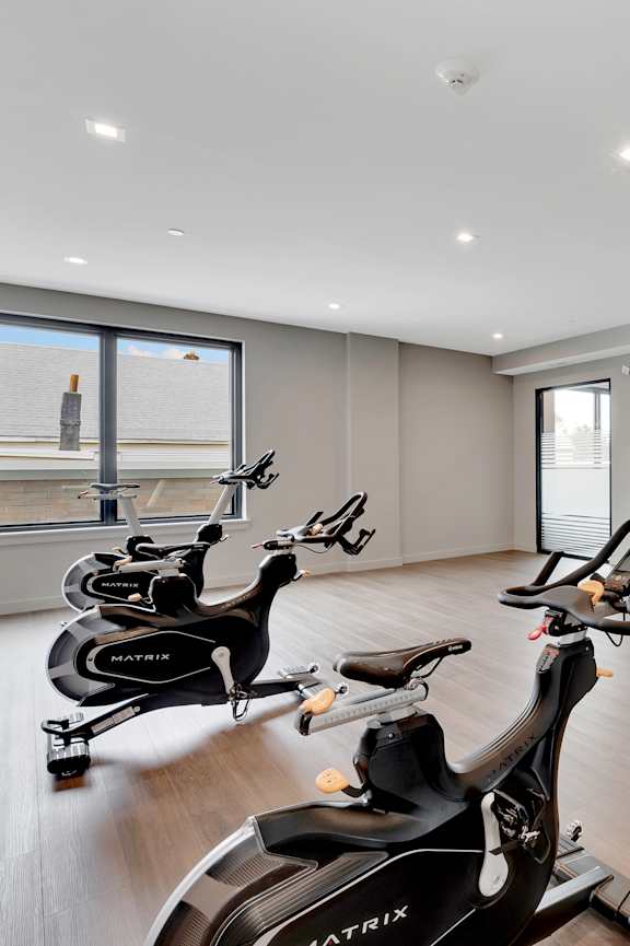 a gym with exercise bikes and a flat screen tv