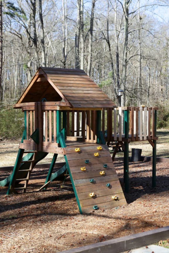 a swing set with a roof and stairs in a park