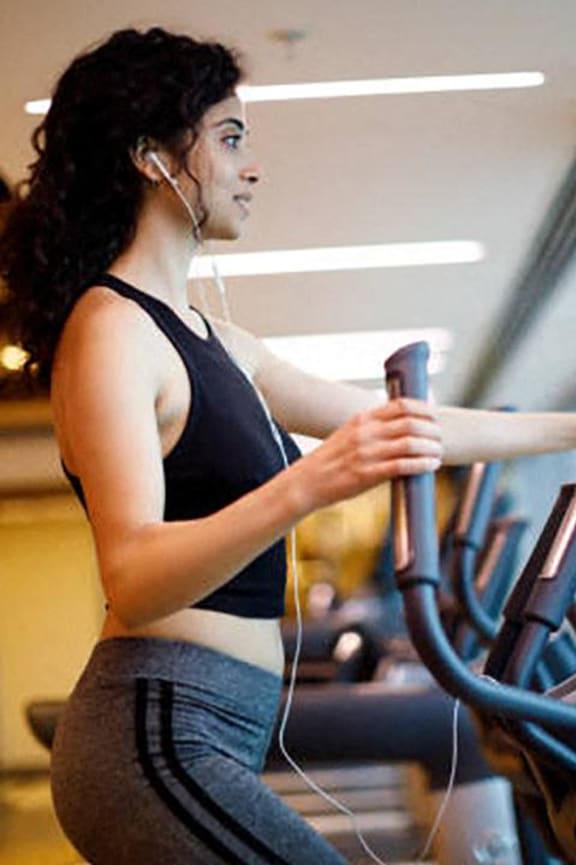 a woman is running on a treadmill in a gym