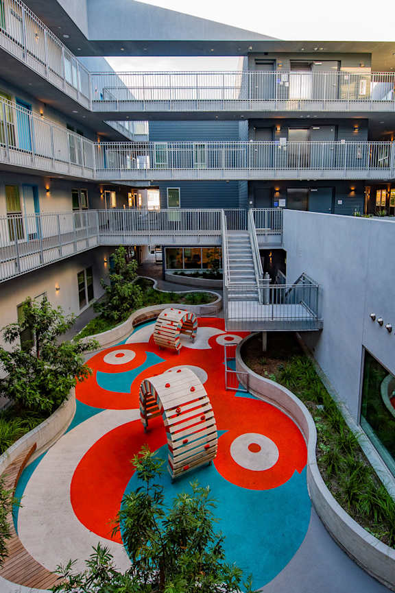 A patio with a table and chairs under a roof.