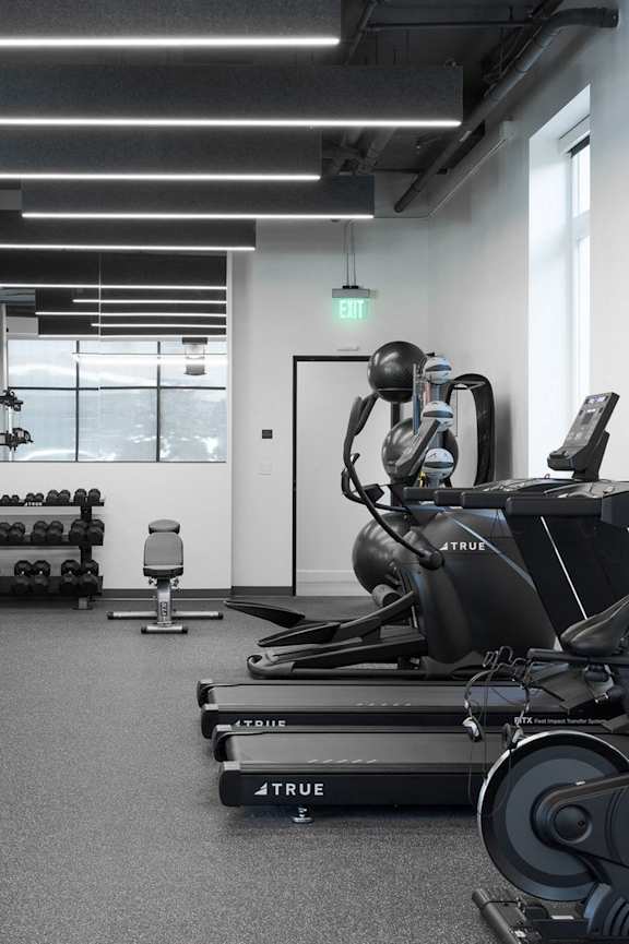 Gym with cardio equipment, weights, treadmills and yoga/workout area at Skylar At Sunset, Los Angeles California