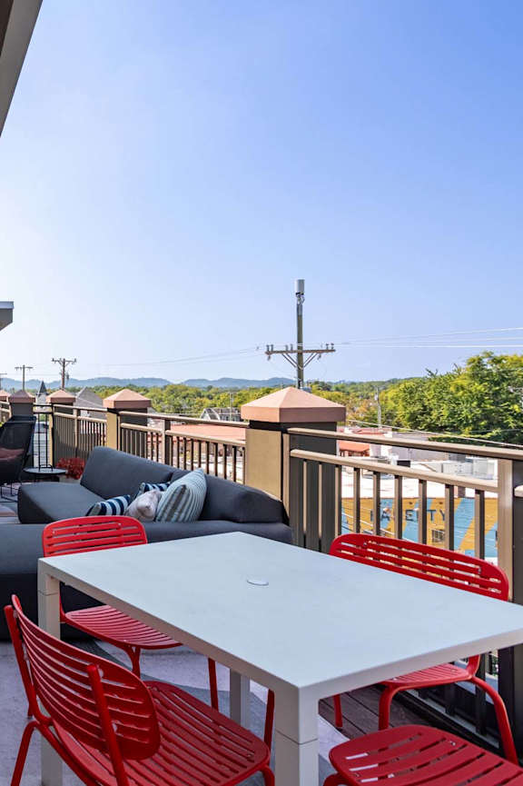 a furnished balcony with a table and chairs and a view of the city