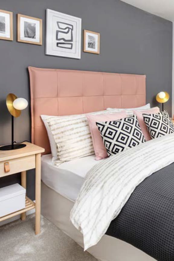 a bedroom with a bed and pillows and pictures on the wall