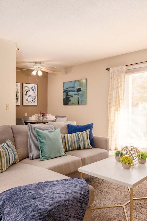 A living room with a grey couch and a white coffee table.