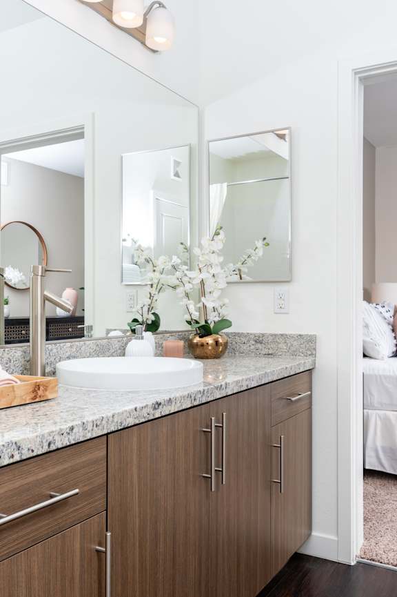 A bathroom with a white sink and a mirror above it.