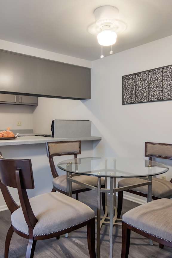 A dining room with a glass table and chairs.