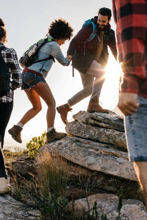 a group of people walking up a rock ledge