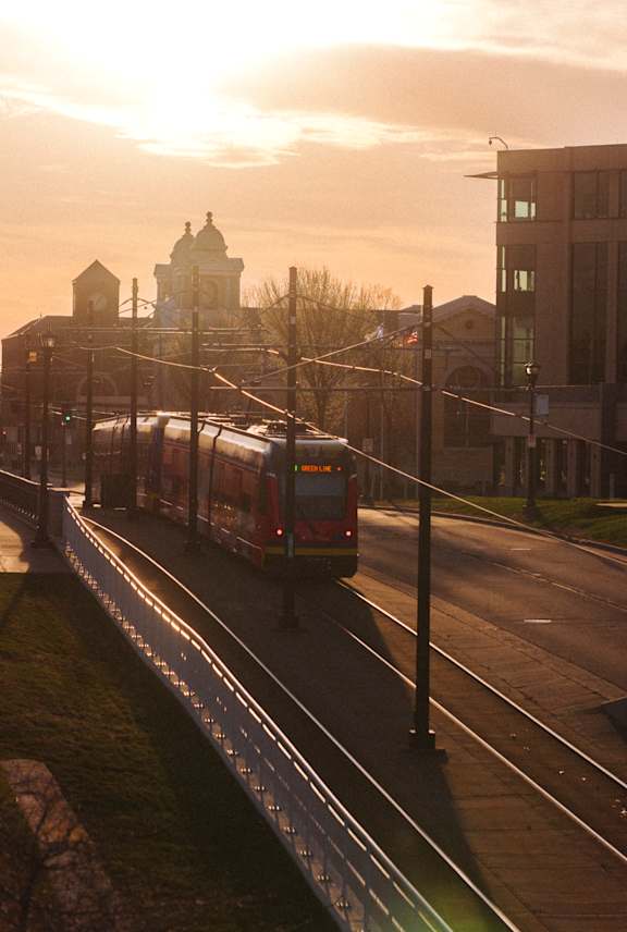 A train is traveling down the tracks in a city.