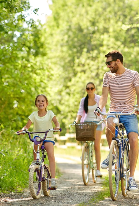 Family riding bikes through a green pathway at Arterra, Washington, 98030