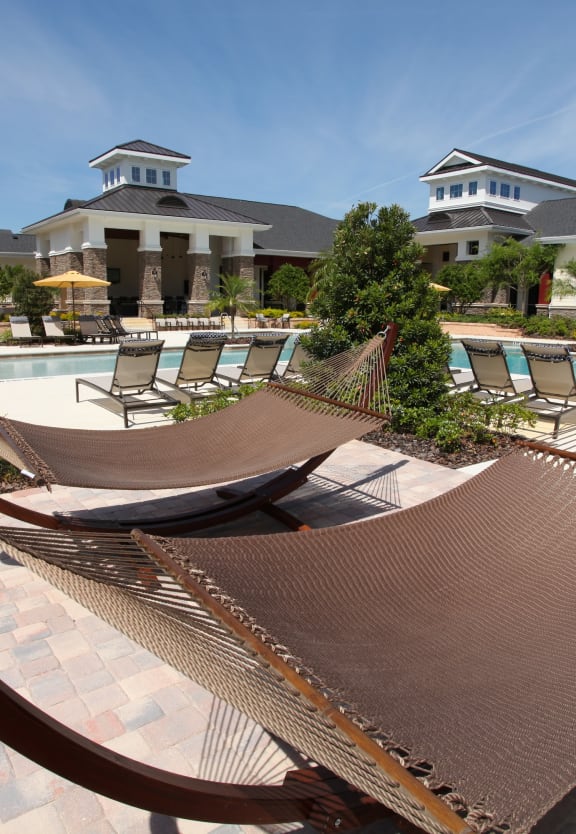 a resort style pool with hammocks and lounge chairs