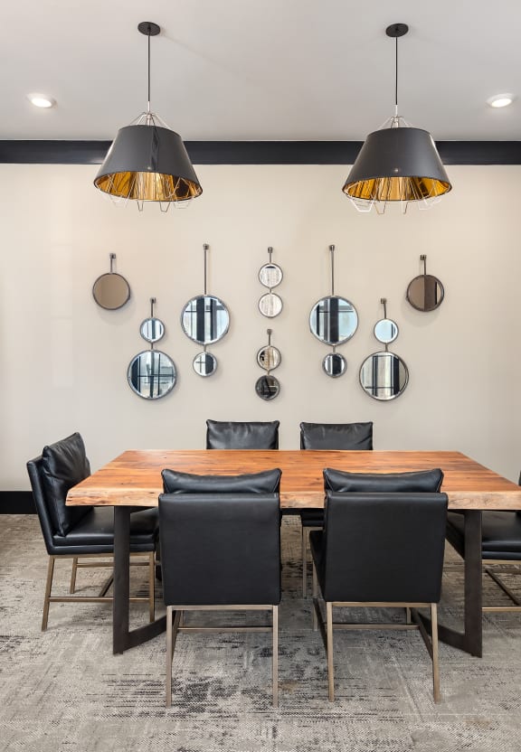 a conference room with a long wooden table and black chairs at The Flats at Southlawn Apartments, Georgia, 30046