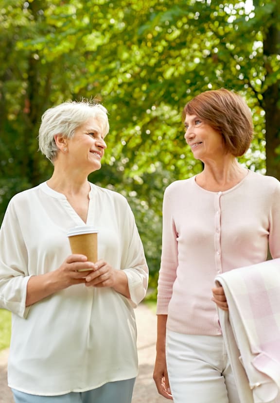 Two women walking in a park and talking.