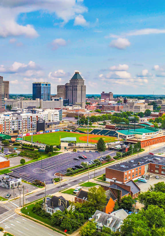 A cityscape with a baseball field in the foreground.