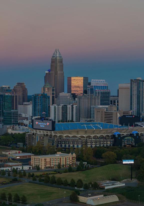 A city skyline at dusk with a highway in the foreground.