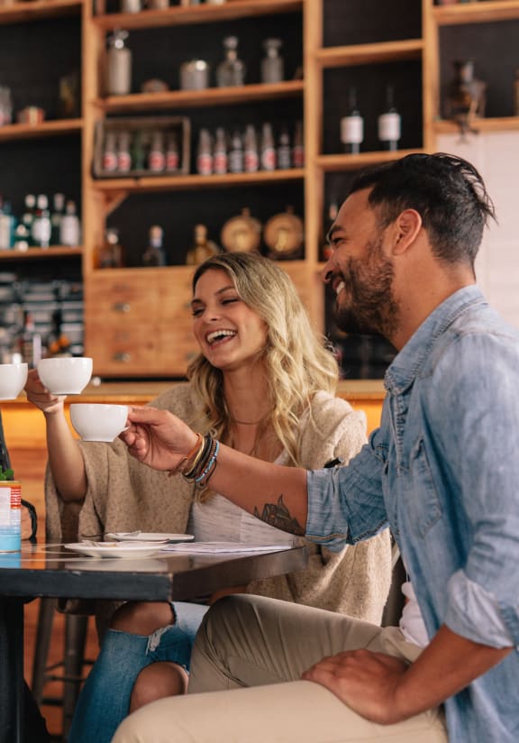 group of people sitting at a table in a restaurant drinking coffee