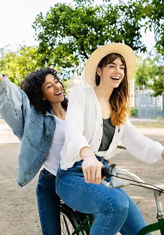 Two women riding a bicycle together.