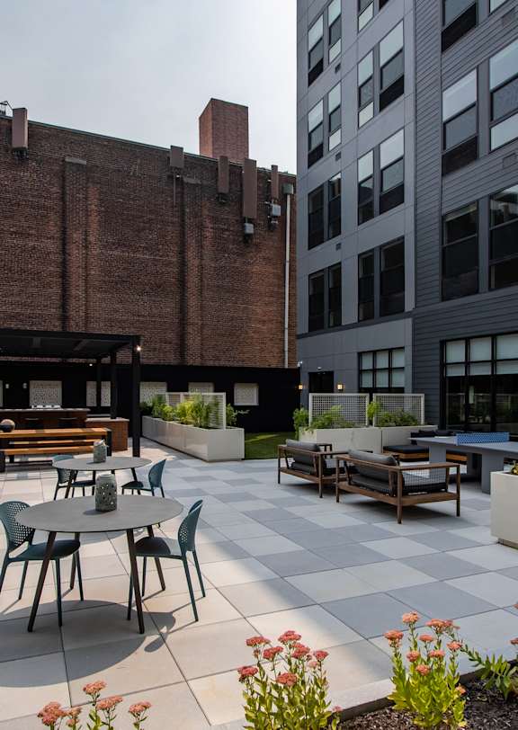 A courtyard with tables and chairs surrounded by buildings.