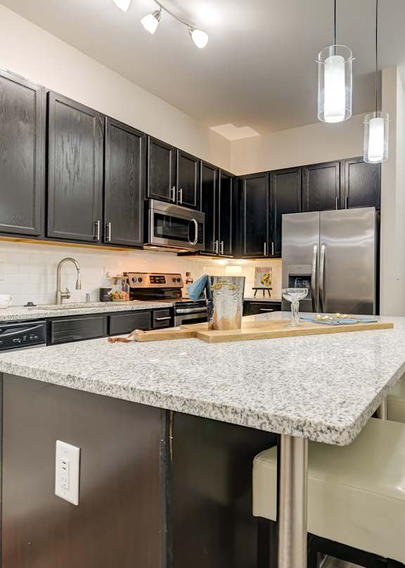 a kitchen with a large island with granite countertops