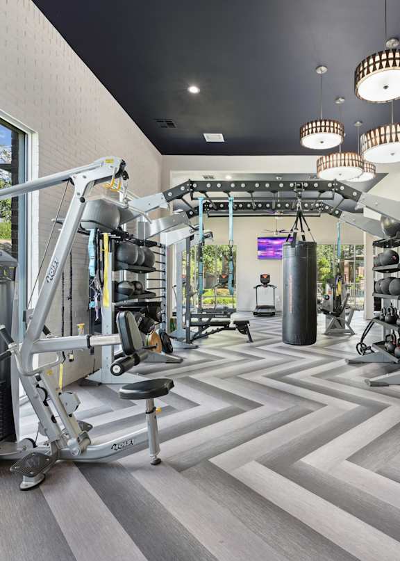 A well-equipped gym with a variety of exercise machines and a large mirror on the wall.