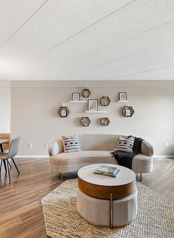 A living room with a blue chair and a white couch.