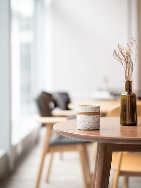 A modern kitchen with a white island and wooden chairs.
