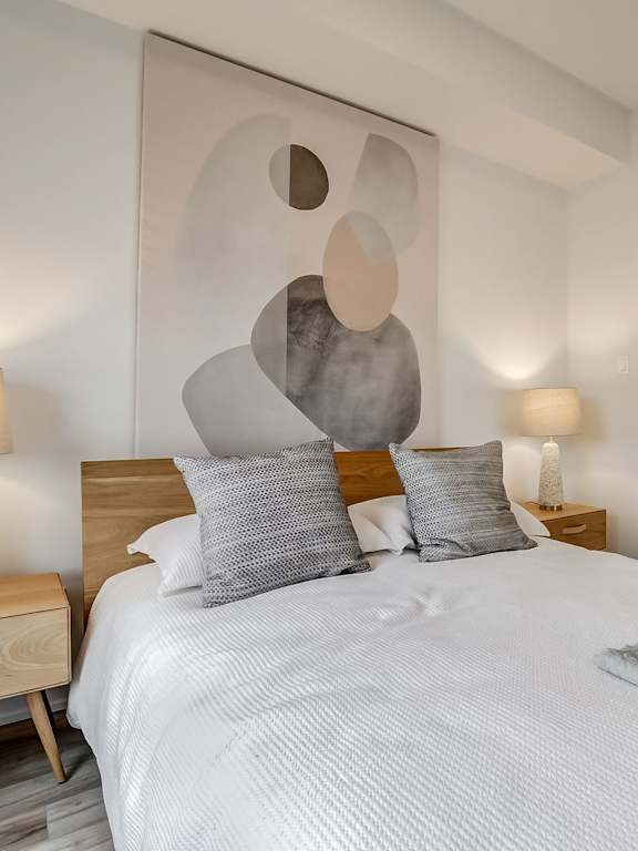 A dining room with a table and chairs and a painting on the wall. at Champlain Village Urbain Apartments , Quebec, J9H 0K9