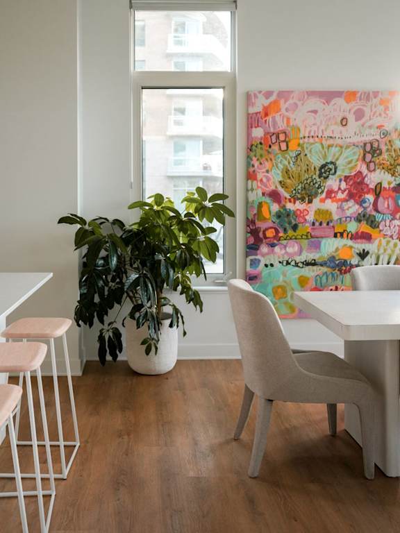A dining room with a table and chairs and a painting on the wall. at Petries Landing I Apartments , Ottawa, ON