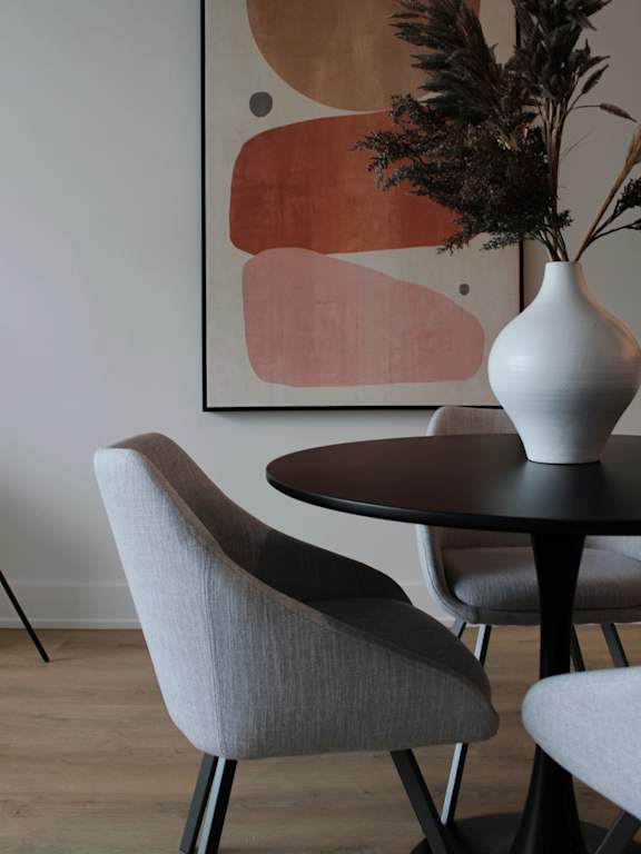 A dining room with a table and chairs and a painting on the wall.at 929 Richmond Apartments, Ottawa, K2B 6R1