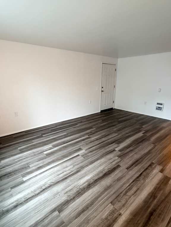 A white wall with a wooden floor.