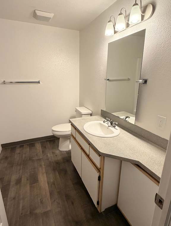 A bathroom with a toilet and a wooden wall.