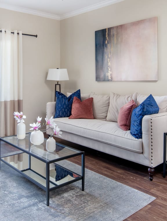 a living room with a white couch and a glass coffee table