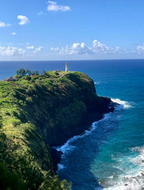 A lighthouse stands on a cliff overlooking the ocean.